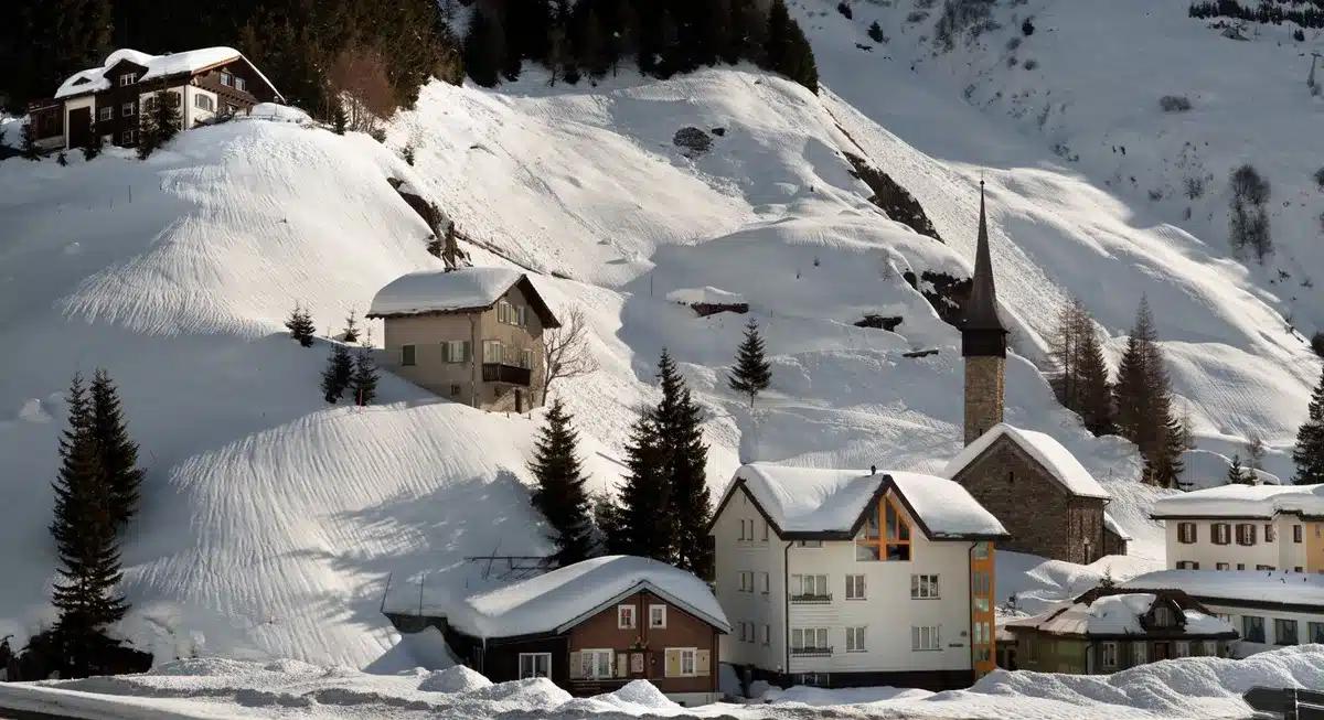 Pueblo alpino con casas de madera cubiertas de nieve en las montañas, atmósfera acogedora de invierno