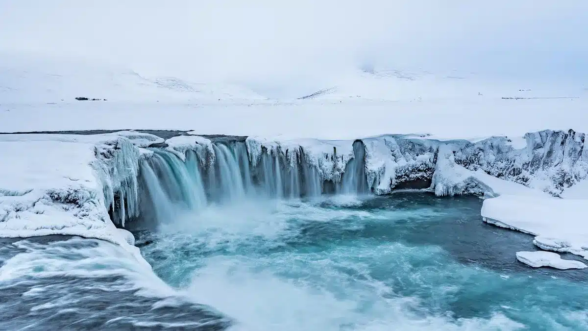 Cascada espectacular en Islandia con agua cayendo desde acantilados rocosos rodeada de paisaje volcánico