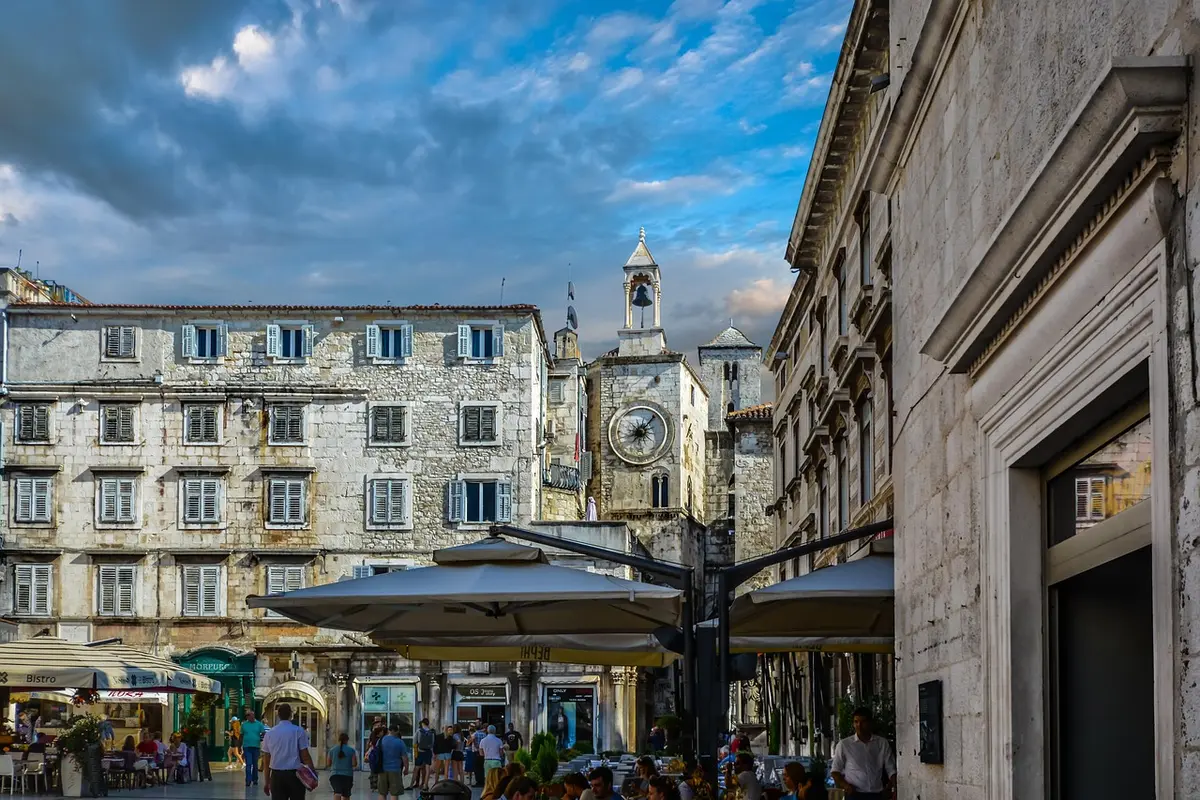 Plaza medieval adoquinada con palacio antiguo y murallas de piedra