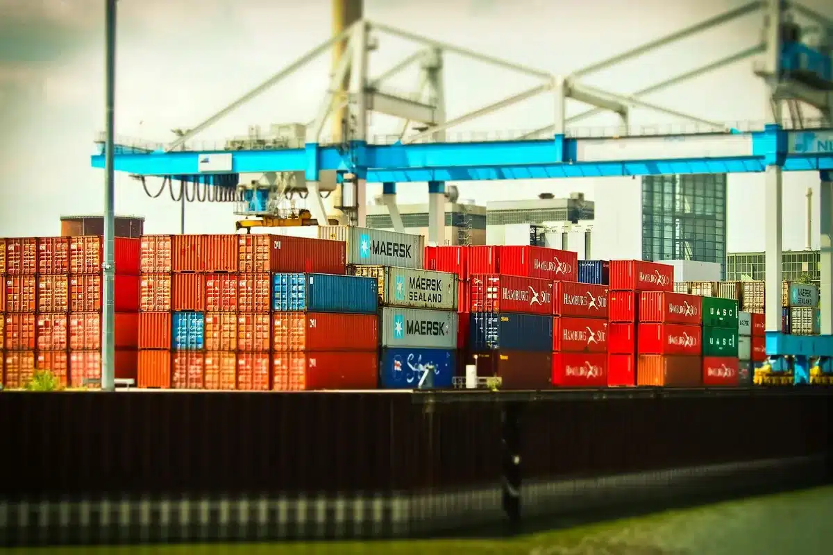 Vista anónima de un muelle portuario con contenedores y una grúa