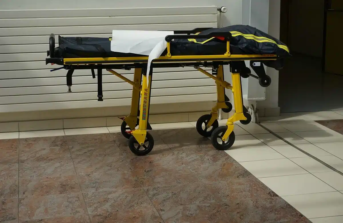 Pasillo de hospital vacío con camillas y una puerta de consultas médicas