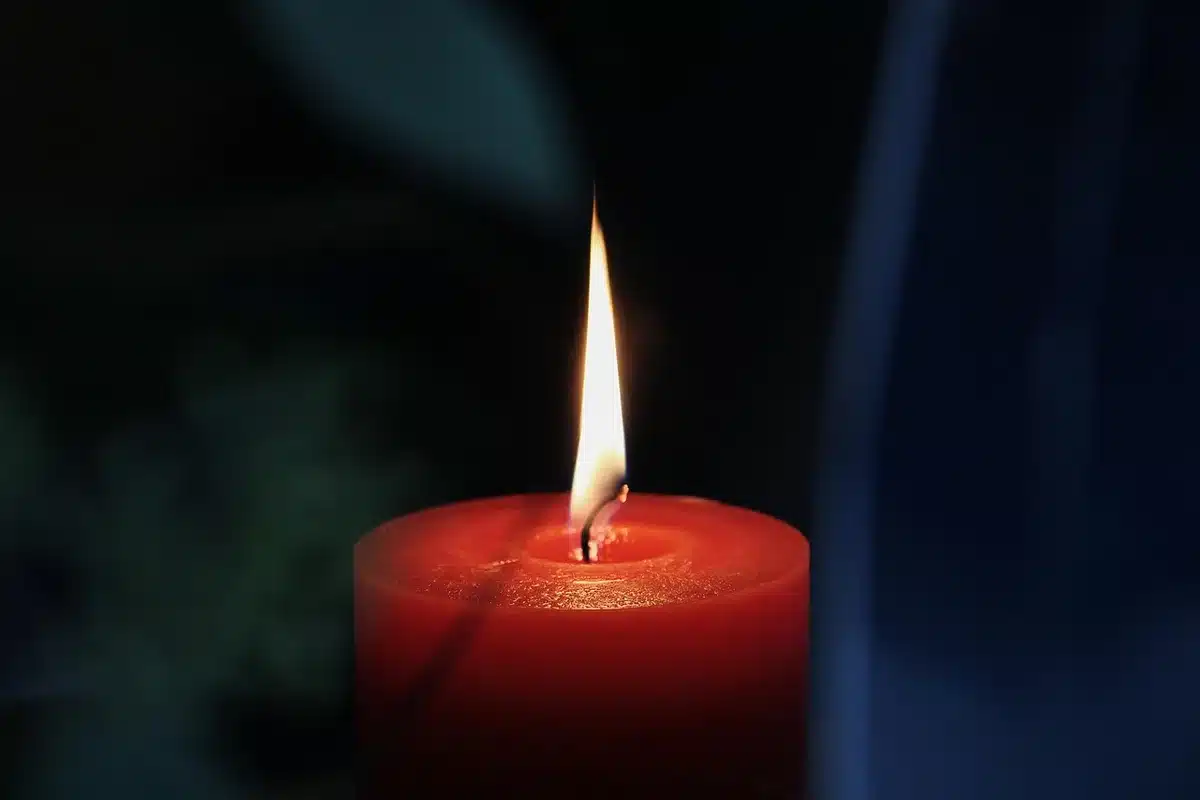 Plaza tranquila de Asís junto a una basílica con velas en primer plano
