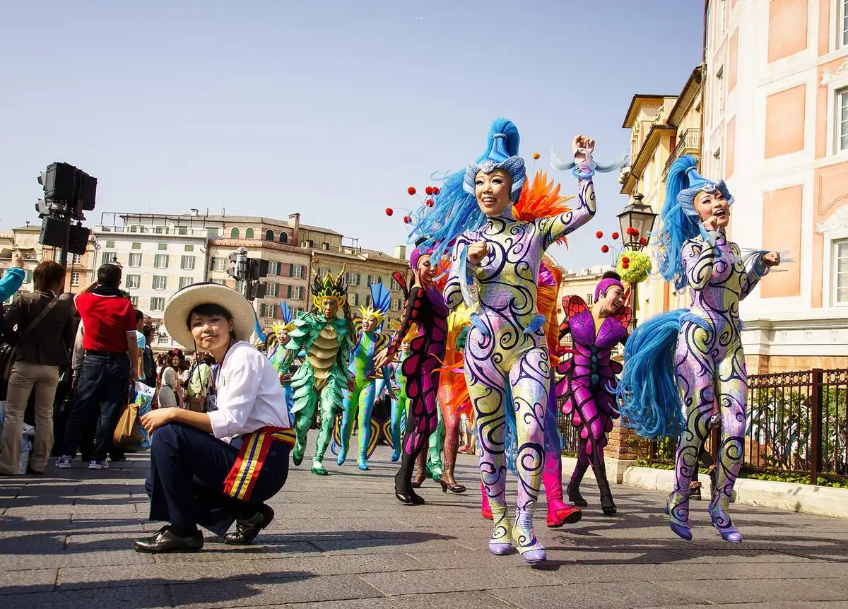 Personas con disfraces coloridos y público en la calle