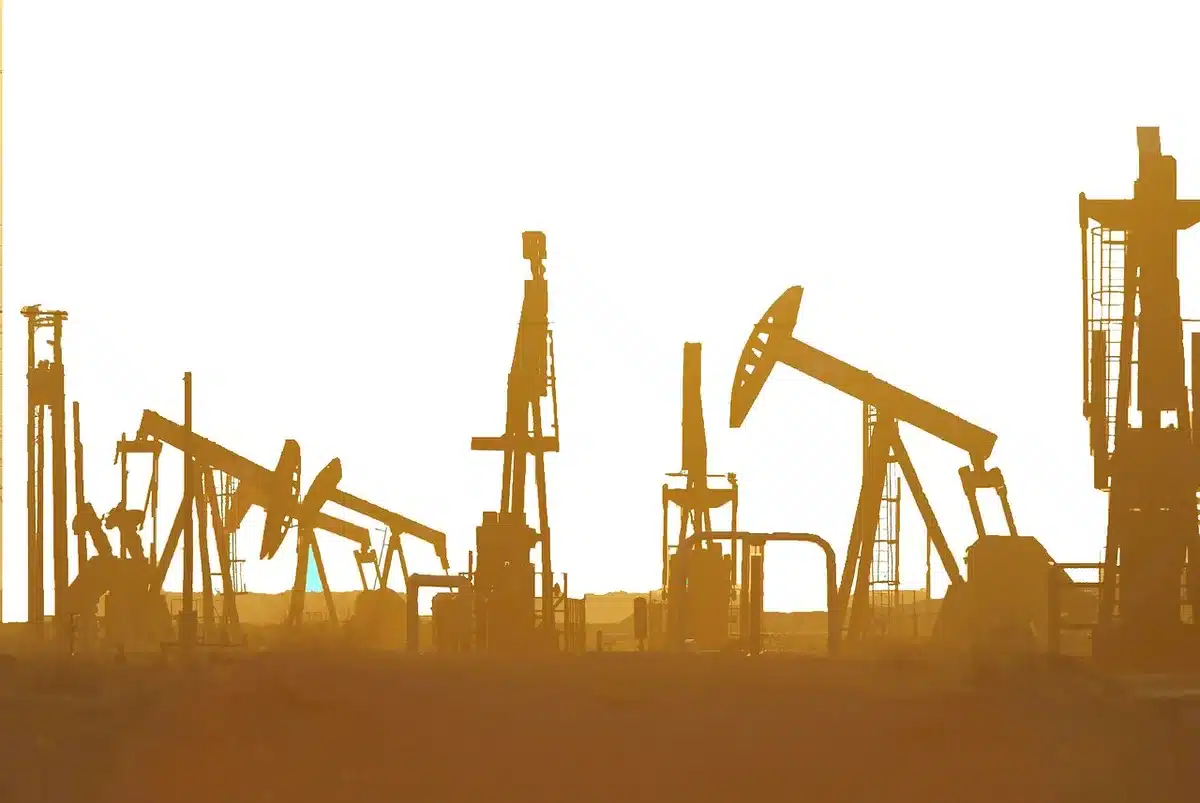 Plataforma petrolera en el mar y manos estrechándose simbólicamente
