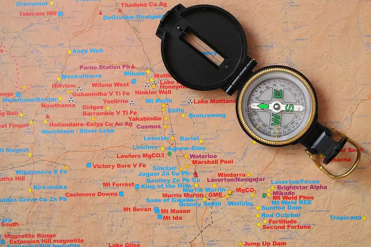 Guía de viaje, mapas y equipo sobre una mesa para planificar una travesía